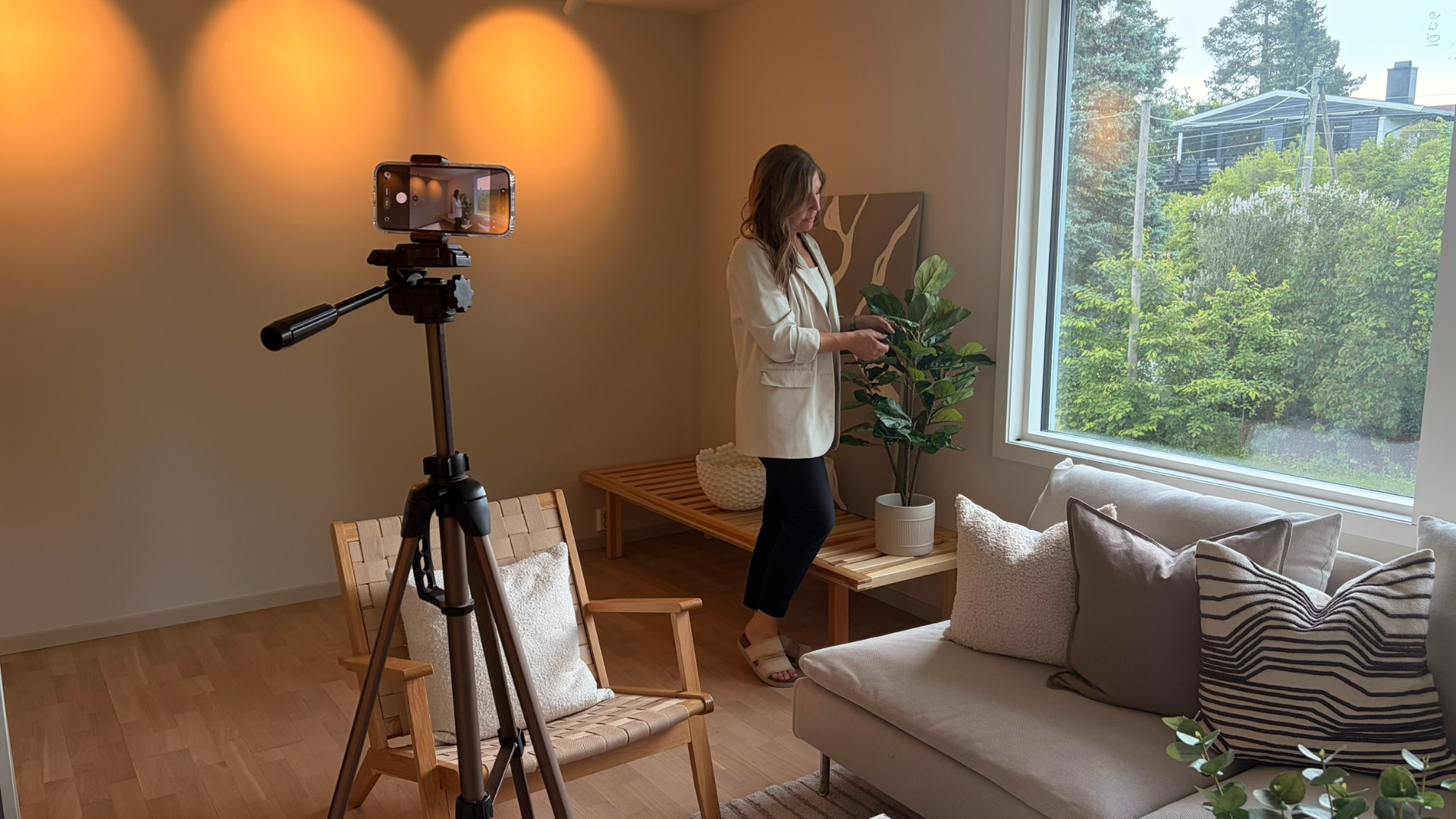 Linda stylinger stuen og rigger kamera før fotografering